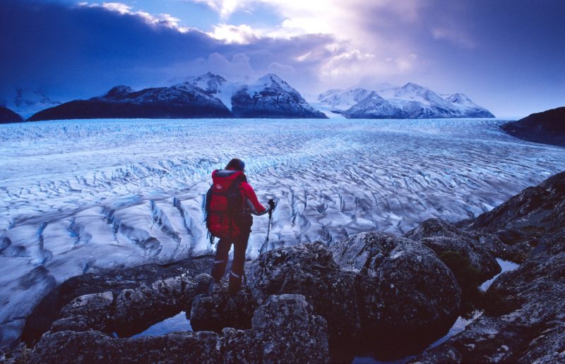 Trekker looking over Glacier Grey, Paine Circuit, Torres del Paine NP, Patagonia, Chile.