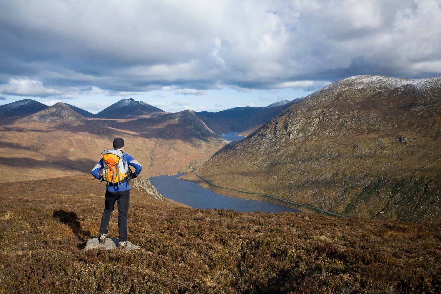 Walker looking down the Silent Valley from Slievenaglogh, Mourne Mountains, Co Down, Northern Ireland. Walker looking down the Silent Valley from Slievenaglogh, Mourne Mountains, Co Down, Northern Ireland.