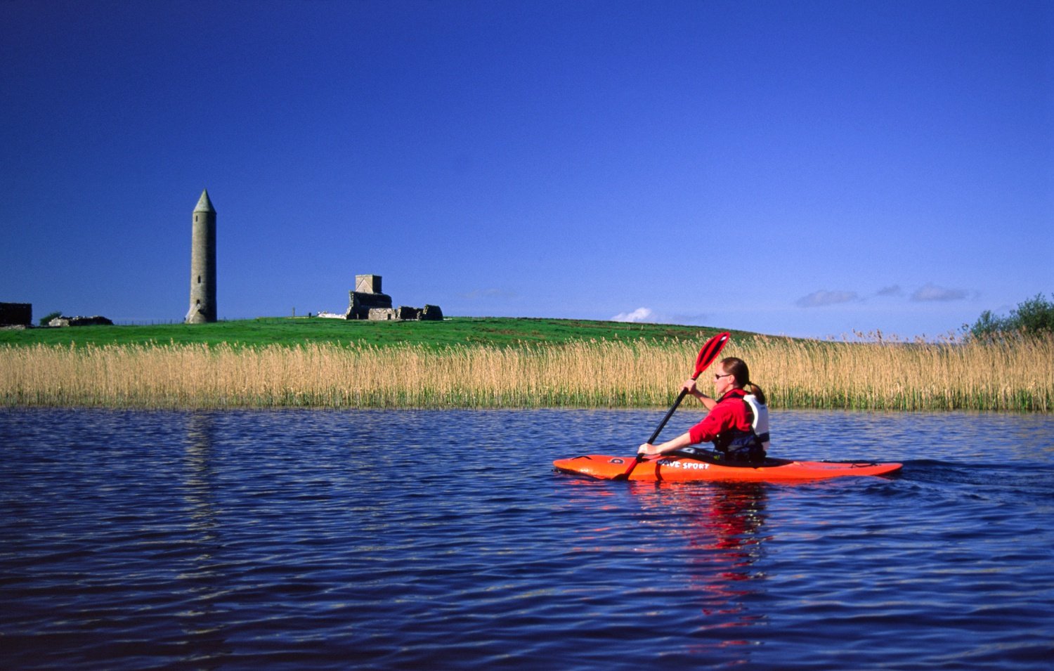 Kayaking past Devenish Island, Lower Lough Erne, Co Fermanagh, Northern Ireland. Kayaking past Devenish Island, Lower Lough Erne, Co Fermanagh, Northern Ireland.