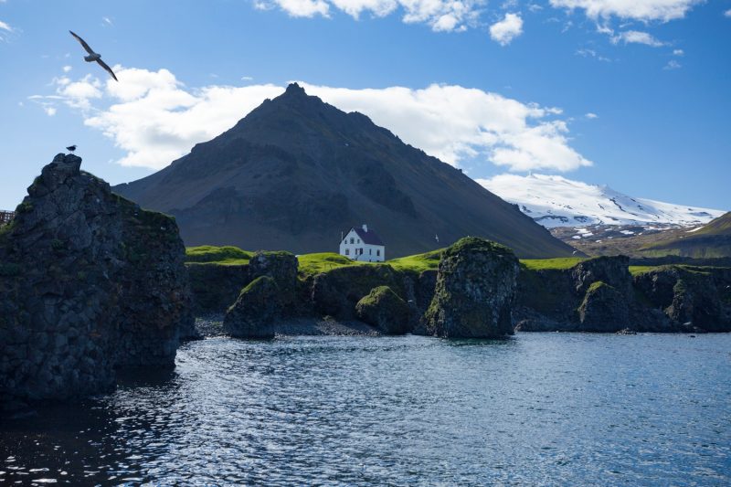 House beneath Stapafell and Snaefellsjokull glacier, Arnarstapi, Snaefellsnes Peninsula, Vesturland, Iceland.