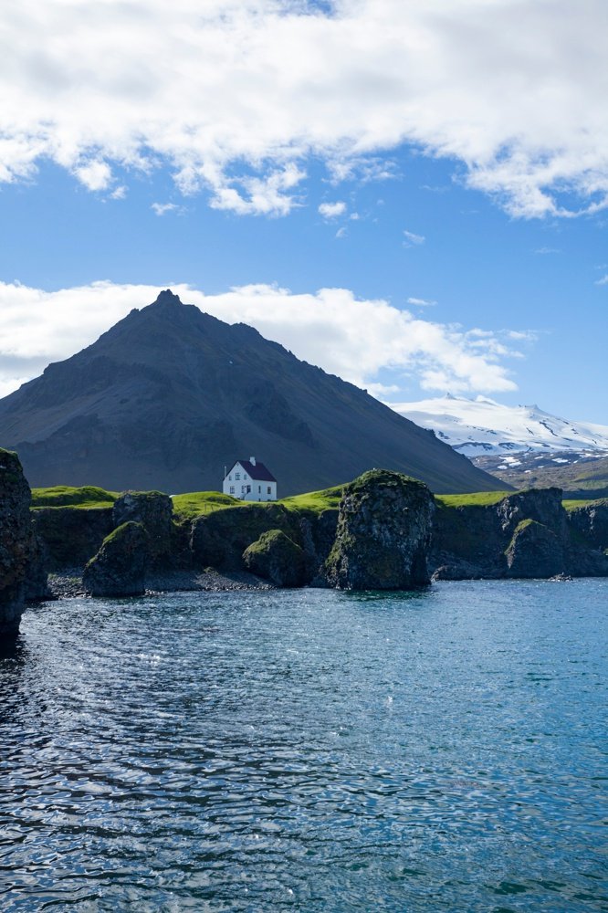 House beneath Stapafell and Snaefellsjokull glacier, Arnarstapi, Snaefellsnes Peninsula, Vesturland, Iceland.