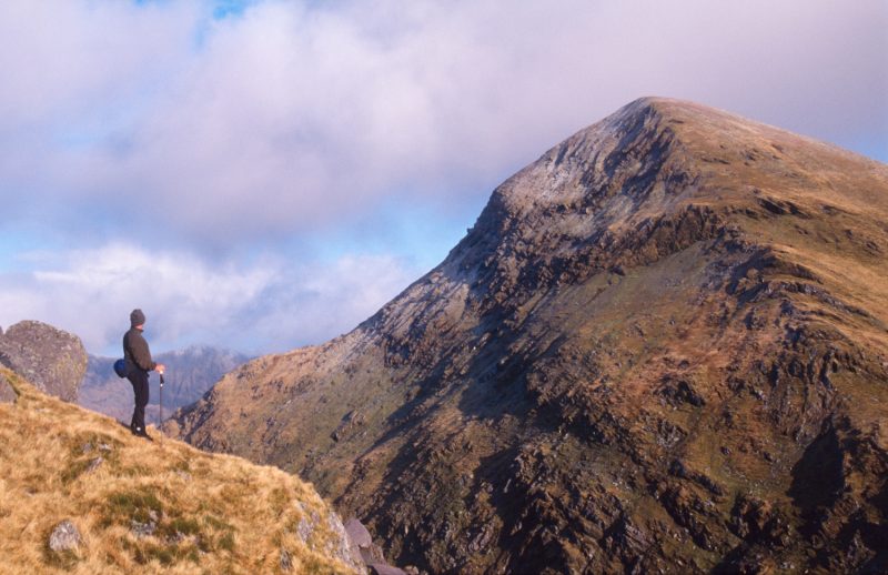Walker beneath Mullaghanattin Mountain, Iveragh Peninsula, Co Kerry, Ireland.