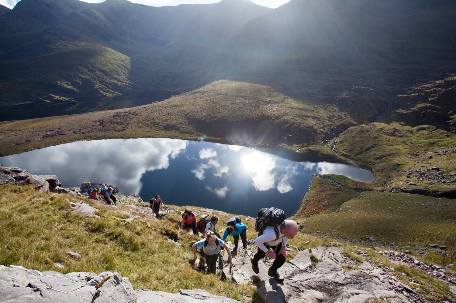 Walkers above Lough Gouragh on the ascent of Carrauntoohill, MacGillycuddy's Reeks, County Kerry, Ireland. Walkers above Lough Gouragh on the ascent of Carrauntoohill, MacGillycuddy's Reeks, County Kerry, Ireland.