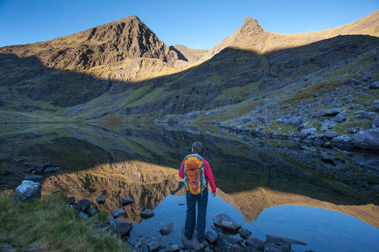 Walker and Lough Gouragh beneath Carrauntoohil, Hag's Glen, MacGillycuddy's Reeks, County Kerry, Ireland. Walker and Lough Gouragh beneath Carrauntoohil, Hag's Glen, MacGillycuddy's Reeks, County Kerry, Ireland.