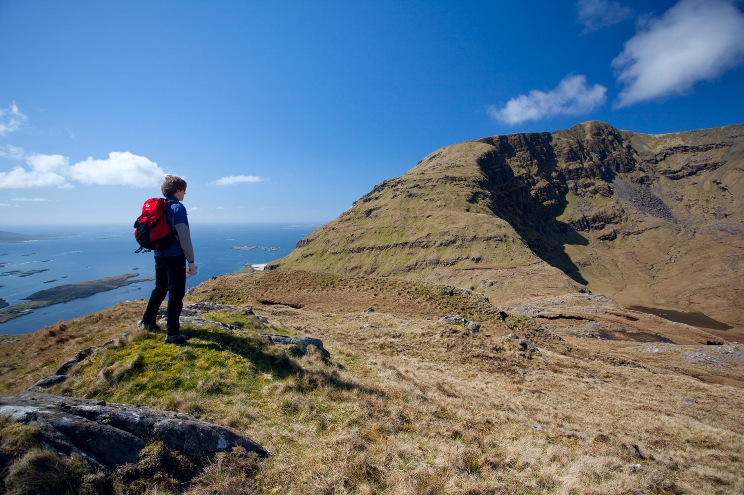 Walker looking across the east face of Mweelrea, Co Mayo, Ireland. Walker looking across the east face of Mweelrea, Co Mayo, Ireland.