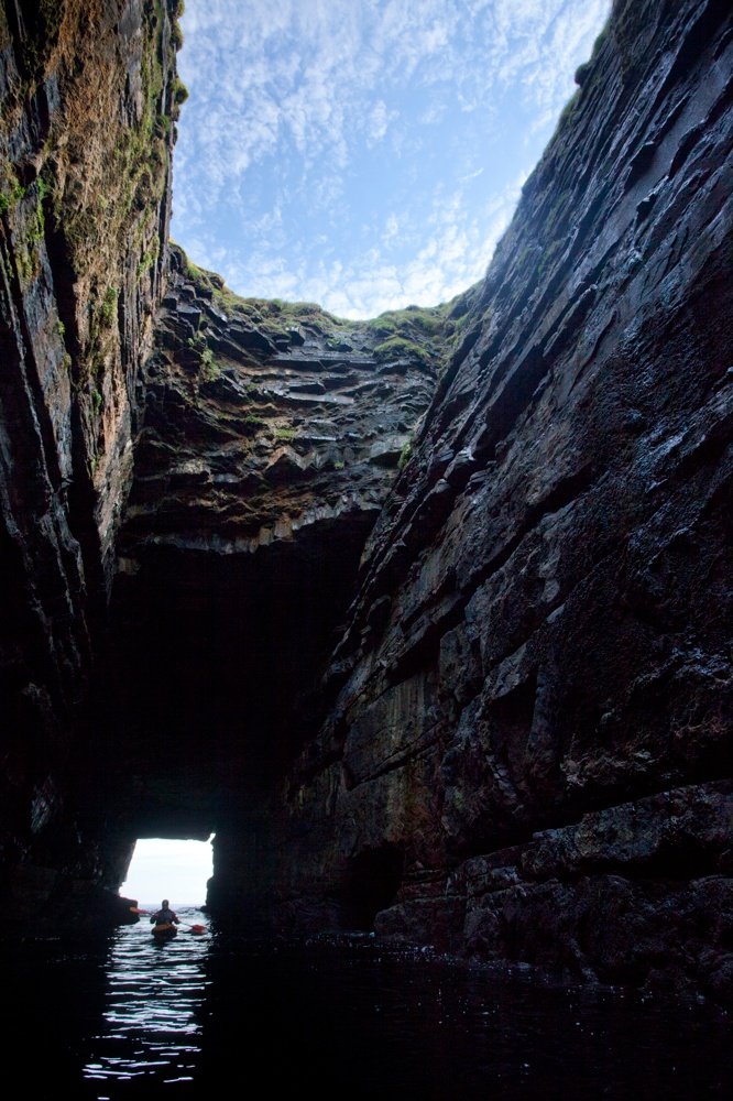 Sea kayaker in the cave beneath Downpatrick Head, Co Mayo, Ireland.